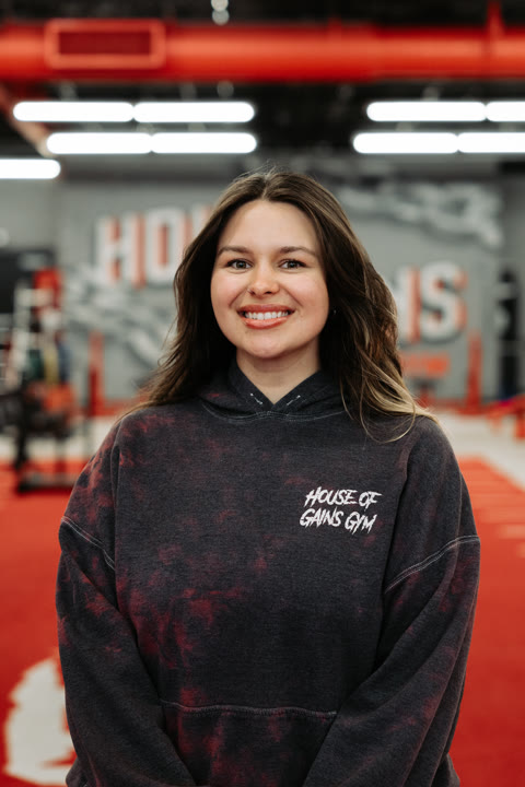 Larissa, of the House of Gains Oxnard crew, on the red turf in front of the House of Gains wall