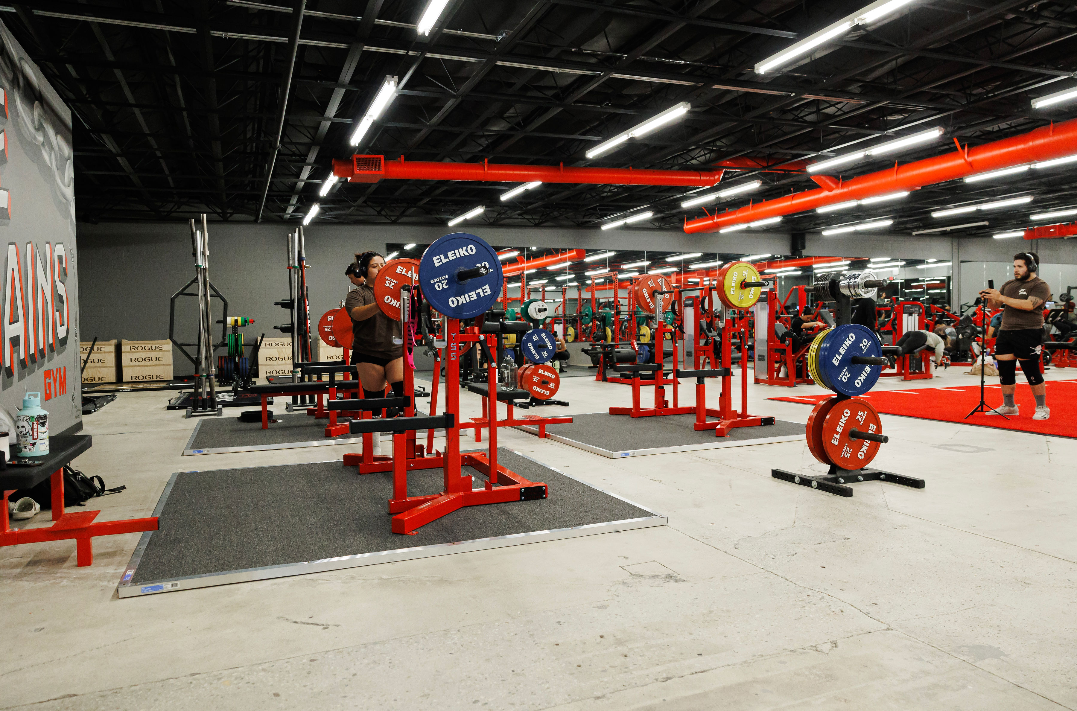 The Oxnard platform row under the House of Gains mural wall, bars racked and loaded